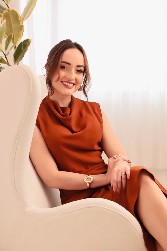 Dra. Idyanara Cangussu em consultório, vestido terracota